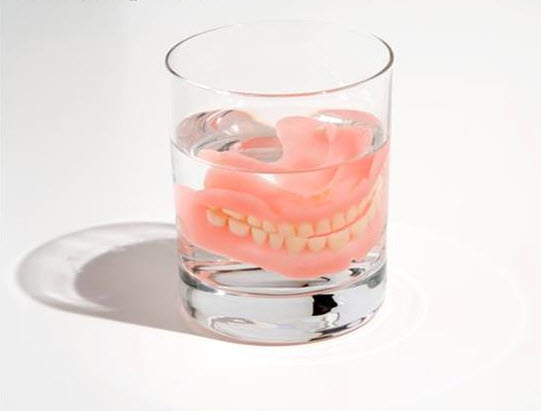 aging senior denture in a glass