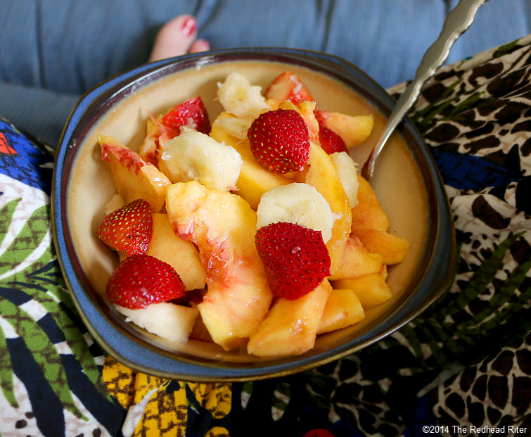 bowl of fruit strawberries peaches bananas in the sunshine