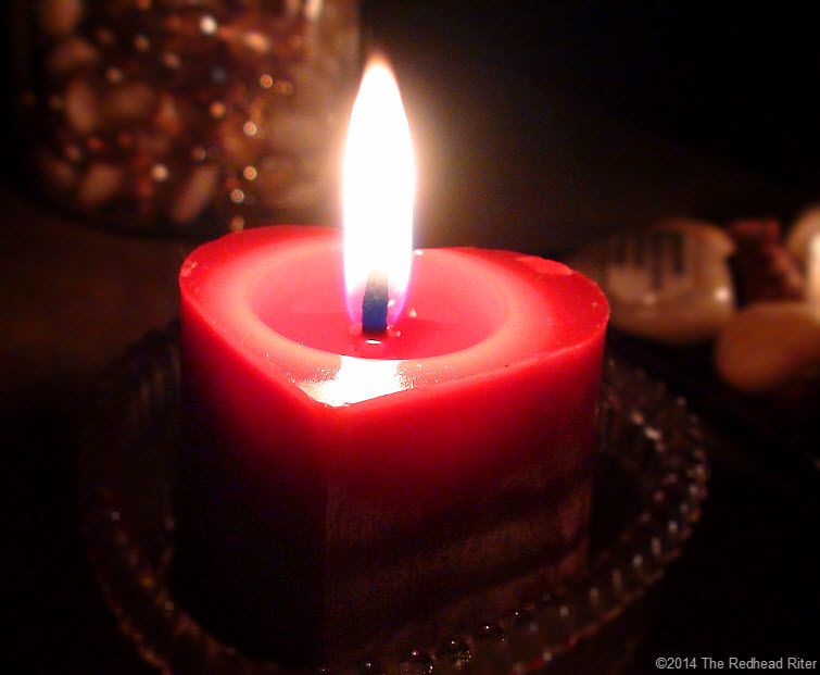 red heart candle buring flame