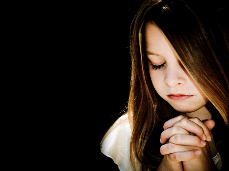 child praying black background